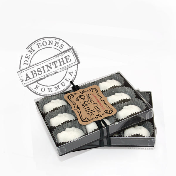 black box, rows of 9 white skulls, skull shaped sugar cubes, absinthe rubber stamp, white background