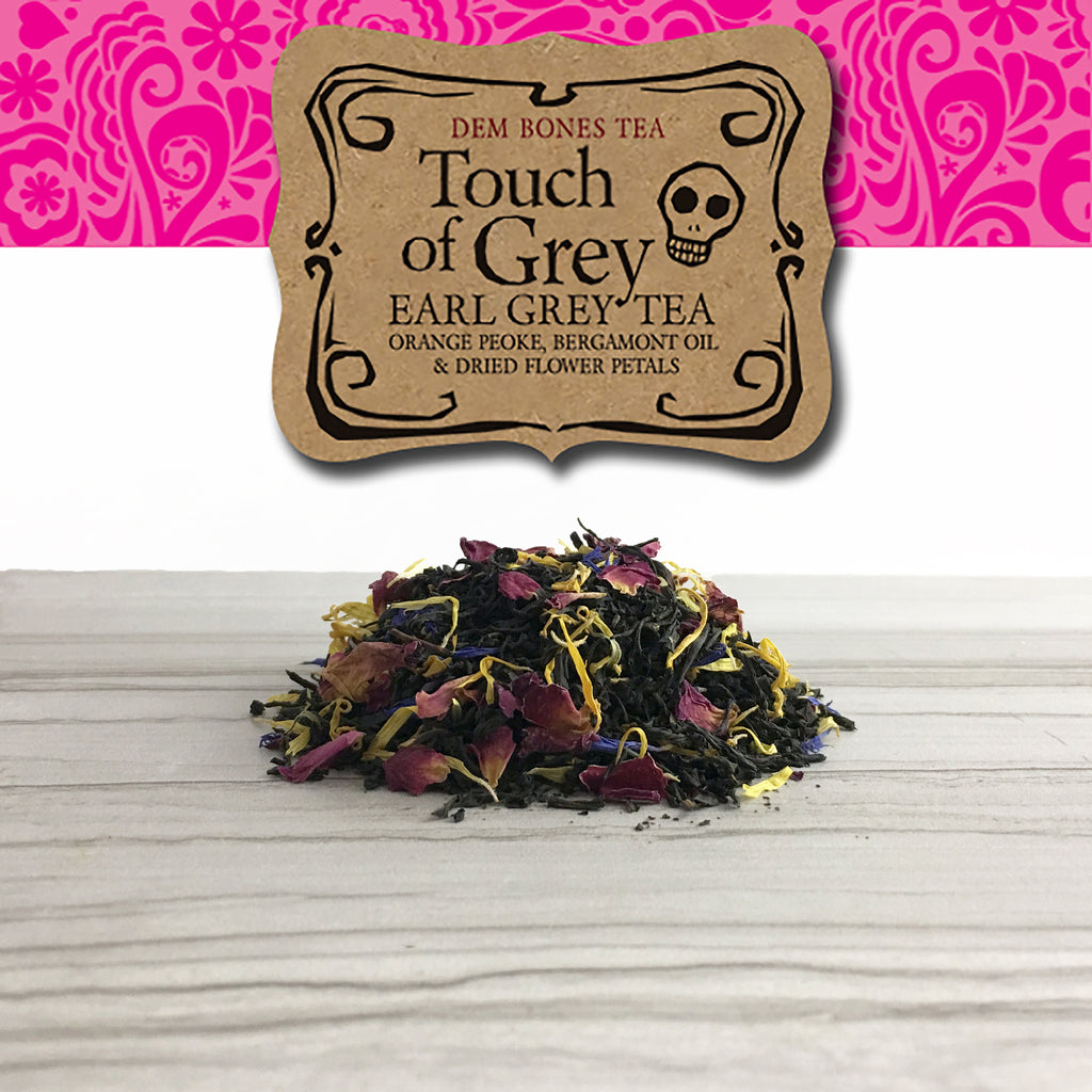 Kraft Label on Pink Band, Dem Bones Tea, Touch Of Grey, Earl Grey Tea,  Orange Peoke, Bergamot Oil & Dried Flower Petals, Pile of tea on light tile