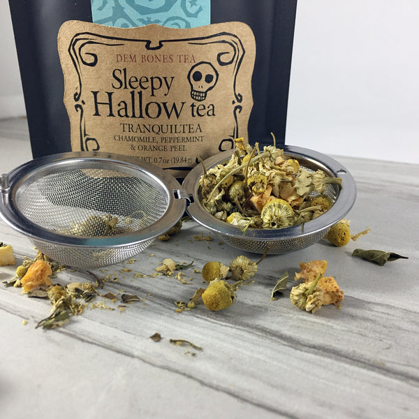 DemBones Sleepy Hallow Tea, Close up of tea in Tea ball , Dried Chamomile and mint close up on light background 