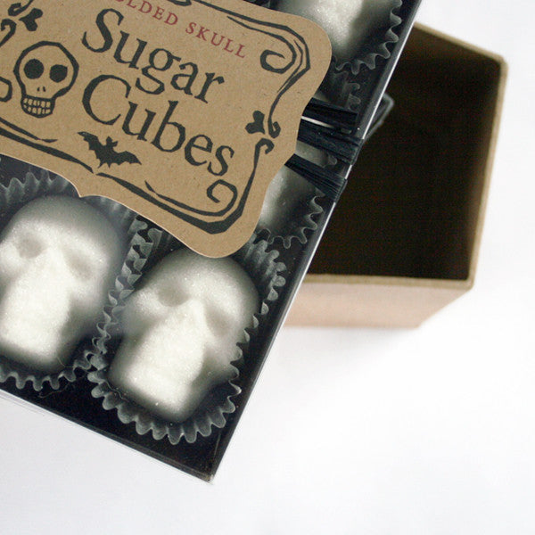 cropped black box, skull sugar cubes, paper candy cups, Sugar Cubes label, white background.